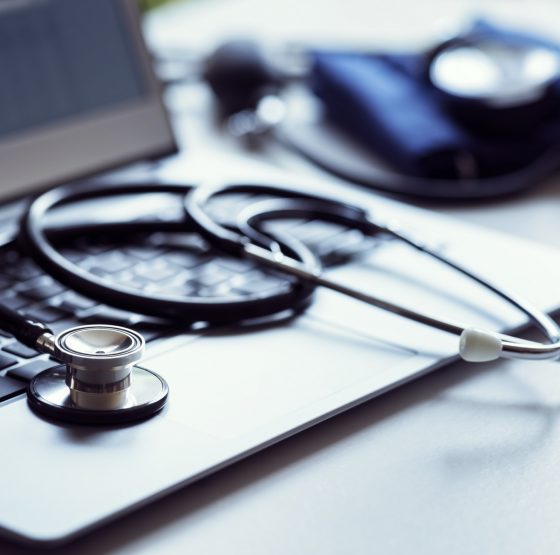 Stethoscope on laptop keyboard in doctor surgery